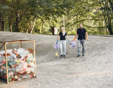 Volunteers collects rubbish. Couple in a park.